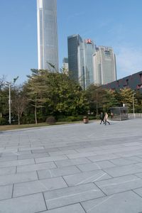 a group of people are walking around in the city on a sunny day with skyscrapers in the background