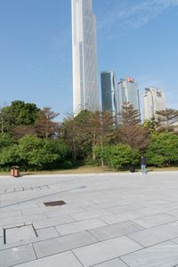 a group of people are walking around in the city on a sunny day with skyscrapers in the background