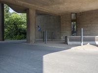 people walking past large concrete building in city setting with parking lot in front of windows