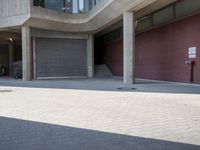 people walking past large concrete building in city setting with parking lot in front of windows