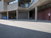 people walking past large concrete building in city setting with parking lot in front of windows