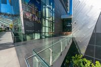 there are many people walking through a building together with some glass walls on either side of them