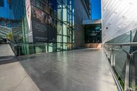 there are many people walking through a building together with some glass walls on either side of them