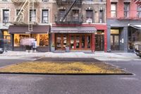 the sidewalk on the city side shows that people are walking outside of the shop front and shopping