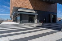 a picture of people walking on a sidewalk near an office building with some stairs in it