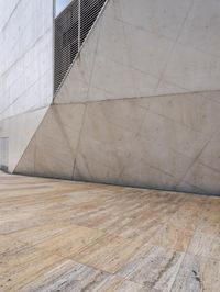 a person on a skateboard on a wooden ground near a building with windows and stairs