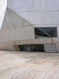 a person on a skateboard on a wooden ground near a building with windows and stairs