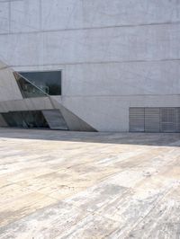 a person on a skateboard on a wooden ground near a building with windows and stairs