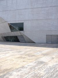 a person on a skateboard on a wooden ground near a building with windows and stairs