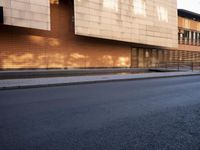 a person walking across an empty street in front of an office building and parking meter