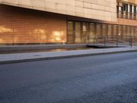 a person walking across an empty street in front of an office building and parking meter