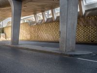 a person with an umbrella walks down a street under a bridge where there is only a few people