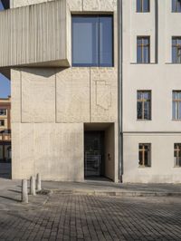 a person with a suitcase walking across an outside courtyard in front of a building,