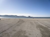 there is a person walking across the beach on a sunny day at the seaside shore