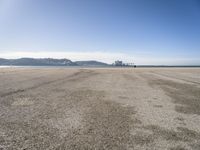 there is a person walking across the beach on a sunny day at the seaside shore