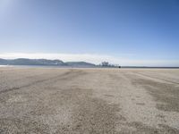 there is a person walking across the beach on a sunny day at the seaside shore