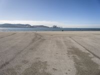 there is a person walking across the beach on a sunny day at the seaside shore