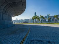 a person walking near a tunnel in a city park with a view of tall buildings