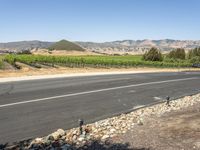 a rural view with a road and fields in the background and mountains in the distance