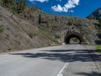 a road goes into a tunnel and through the hill to the other side of it