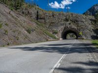 a road goes into a tunnel and through the hill to the other side of it