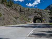 a road goes into a tunnel and through the hill to the other side of it