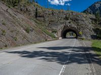 a road goes into a tunnel and through the hill to the other side of it