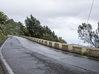 a sign indicating right lane is left behind a steep hill on a street corner next to a steep cliff