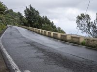 a sign indicating right lane is left behind a steep hill on a street corner next to a steep cliff