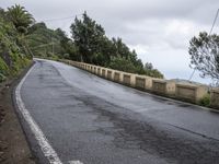 a sign indicating right lane is left behind a steep hill on a street corner next to a steep cliff