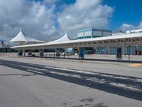 a white terminal with many windows, blue sky and clouds in the background of it