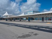 a white terminal with many windows, blue sky and clouds in the background of it