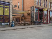 a red fire hydrant sitting in front of an old store window and building next to an open air field