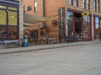 a red fire hydrant sitting in front of an old store window and building next to an open air field