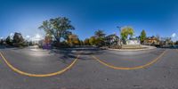 a street view of a crosswalk with houses and trees on either side of it