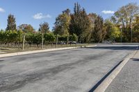 a paved roadway in an empty field area with parked bikes on either side of it