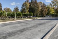 a paved roadway in an empty field area with parked bikes on either side of it