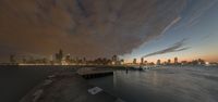 a long exposure shot of the chicago skyline with water and clouds at sunset in a city