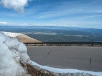 the man is at the top of a mountain on skis with mountains in the background