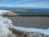 the man is at the top of a mountain on skis with mountains in the background