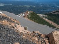 a snow covered road is near a very steep cliff on a clear day the wall is filled with snow and snow