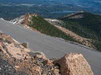 a snow covered road is near a very steep cliff on a clear day the wall is filled with snow and snow