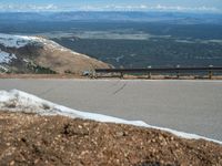 the man is at the top of a mountain on skis with mountains in the background