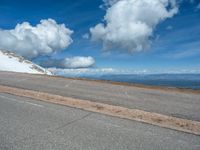 the man is at the top of a mountain on skis with mountains in the background