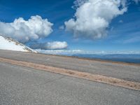 the man is at the top of a mountain on skis with mountains in the background