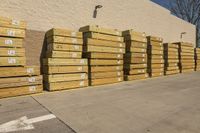 several piles of boxes sit in the street near a building, including one for sale