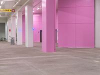 a pink hallway with lots of windows and doors on both sides of it and flooring
