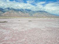 an image of a pink lake in the desert with mountains in the background's horizon