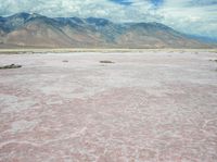 an image of a pink lake in the desert with mountains in the background's horizon