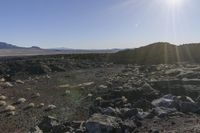 the sun shines brightly above the rocky area with rocks, boulders and vegetation surrounding